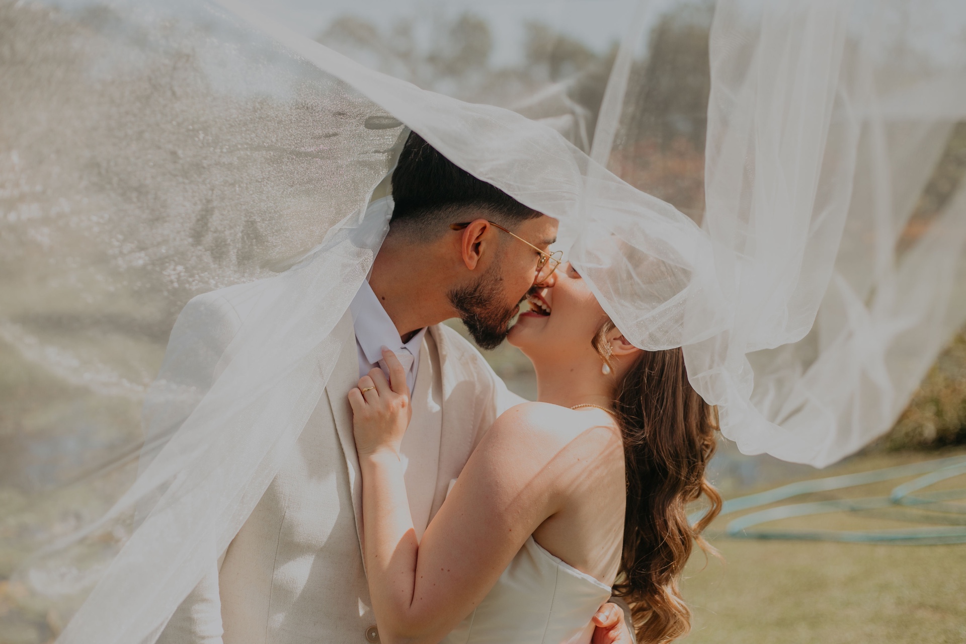 Casal sob o véu ao vento — capturado pela Bind Creative